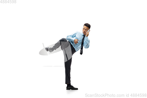 Image of Man in office clothes practicing taekwondo on white background. Unusual look for businessman in motion, action. Sport, healthy lifestyle.