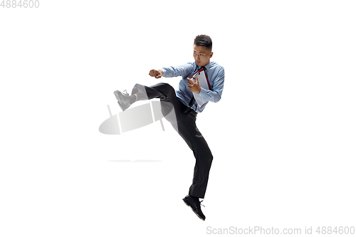 Image of Man in office clothes practicing taekwondo on white background. Unusual look for businessman in motion, action. Sport, healthy lifestyle.