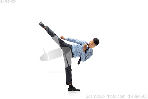 Image of Man in office clothes practicing taekwondo on white background. Unusual look for businessman in motion, action. Sport, healthy lifestyle.