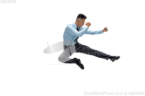 Image of Man in office clothes practicing taekwondo on white background. Unusual look for businessman in motion, action. Sport, healthy lifestyle.