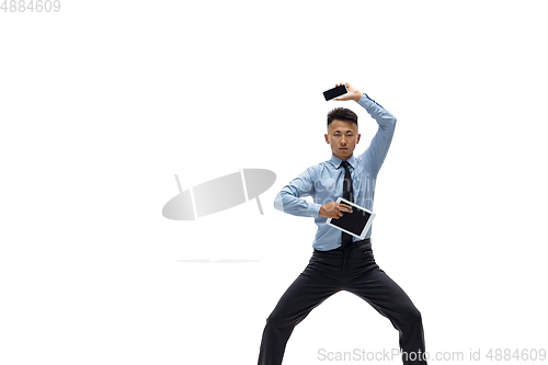 Image of Man in office clothes practicing taekwondo on white background. Unusual look for businessman in motion, action. Sport, healthy lifestyle.