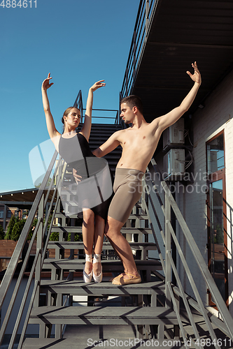 Image of Couple of modern ballet dancers performing on the stairs at the city