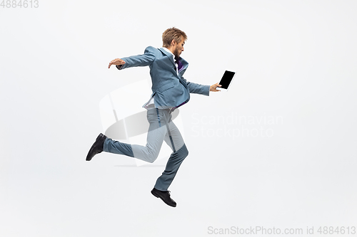 Image of Man in office clothes running, jogging on white background. Unusual look for businessman in motion, action. Sport, healthy lifestyle.