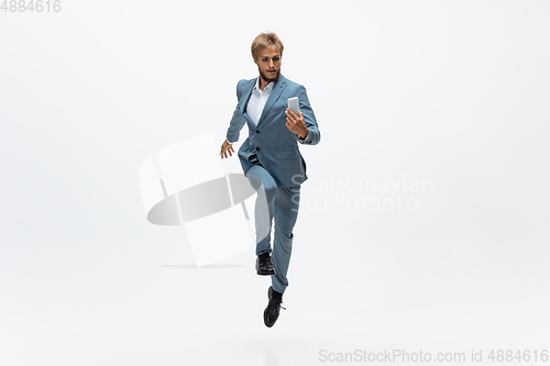 Image of Man in office clothes running, jogging on white background. Unusual look for businessman in motion, action. Sport, healthy lifestyle.