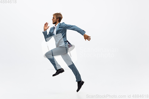 Image of Man in office clothes running, jogging on white background. Unusual look for businessman in motion, action. Sport, healthy lifestyle.