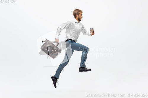 Image of Man in office clothes running, jogging on white background. Unusual look for businessman in motion, action. Sport, healthy lifestyle.