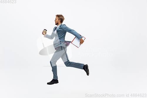 Image of Man in office clothes running, jogging on white background. Unusual look for businessman in motion, action. Sport, healthy lifestyle.