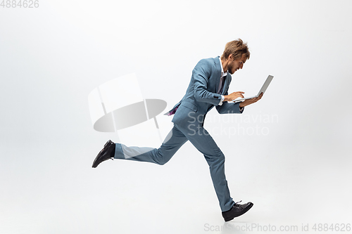 Image of Man in office clothes running, jogging on white background. Unusual look for businessman in motion, action. Sport, healthy lifestyle.