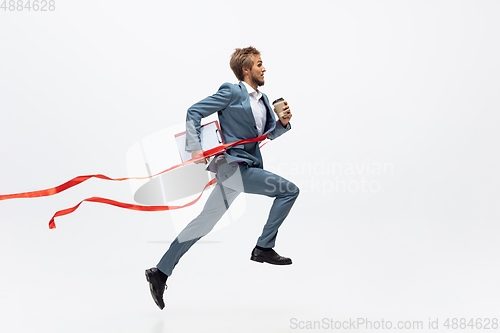 Image of Man in office clothes running, jogging on white background. Unusual look for businessman in motion, action. Sport, healthy lifestyle.