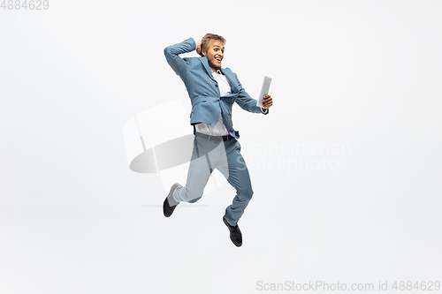 Image of Man in office clothes running, jogging on white background. Unusual look for businessman in motion, action. Sport, healthy lifestyle.