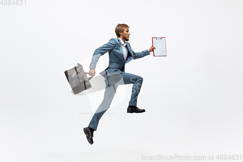 Image of Man in office clothes running, jogging on white background. Unusual look for businessman in motion, action. Sport, healthy lifestyle.