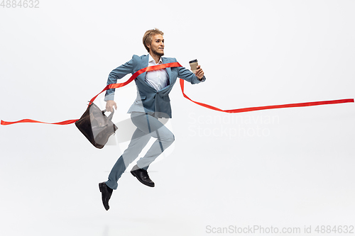 Image of Man in office clothes running, jogging on white background. Unusual look for businessman in motion, action. Sport, healthy lifestyle.