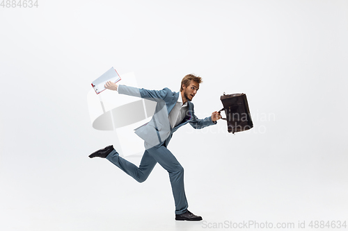 Image of Man in office clothes running, jogging on white background. Unusual look for businessman in motion, action. Sport, healthy lifestyle.