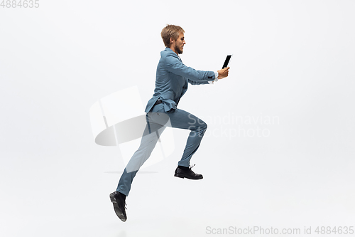 Image of Man in office clothes running, jogging on white background. Unusual look for businessman in motion, action. Sport, healthy lifestyle.