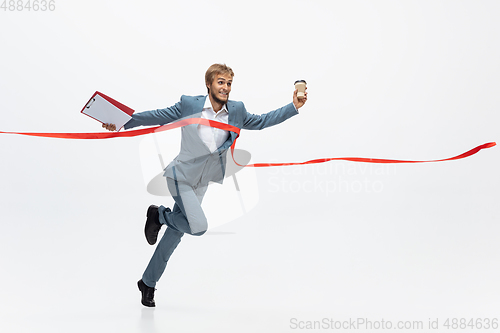 Image of Man in office clothes running, jogging on white background. Unusual look for businessman in motion, action. Sport, healthy lifestyle.