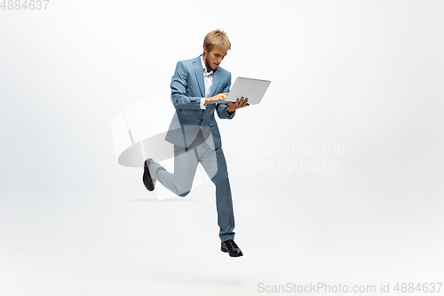 Image of Man in office clothes running, jogging on white background. Unusual look for businessman in motion, action. Sport, healthy lifestyle.