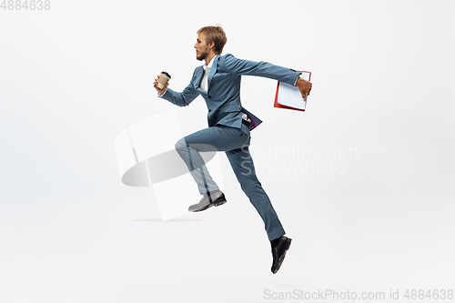 Image of Man in office clothes running, jogging on white background. Unusual look for businessman in motion, action. Sport, healthy lifestyle.