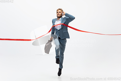 Image of Man in office clothes running, jogging on white background. Unusual look for businessman in motion, action. Sport, healthy lifestyle.