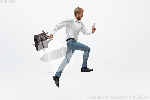 Image of Man in office clothes running, jogging on white background. Unusual look for businessman in motion, action. Sport, healthy lifestyle.