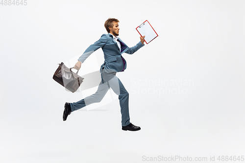 Image of Man in office clothes running, jogging on white background. Unusual look for businessman in motion, action. Sport, healthy lifestyle.