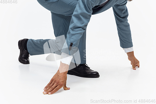 Image of Man in office clothes running, jogging on white background. Unusual look for businessman in motion, action. Sport, healthy lifestyle.