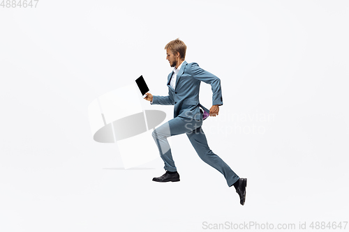 Image of Man in office clothes running, jogging on white background. Unusual look for businessman in motion, action. Sport, healthy lifestyle.