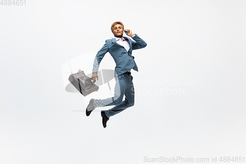 Image of Man in office clothes running, jogging on white background. Unusual look for businessman in motion, action. Sport, healthy lifestyle.