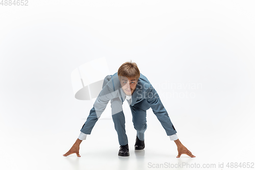 Image of Man in office clothes running, jogging on white background. Unusual look for businessman in motion, action. Sport, healthy lifestyle.