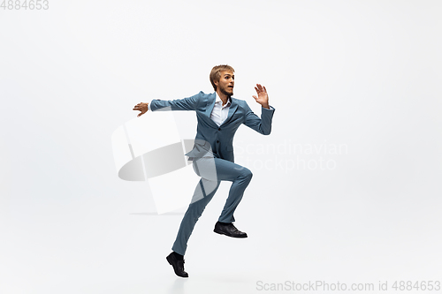 Image of Man in office clothes running, jogging on white background. Unusual look for businessman in motion, action. Sport, healthy lifestyle.