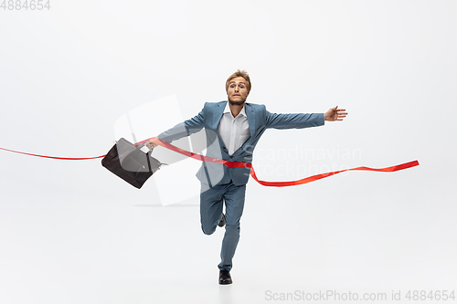 Image of Man in office clothes running, jogging on white background. Unusual look for businessman in motion, action. Sport, healthy lifestyle.