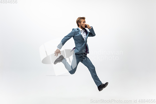 Image of Man in office clothes running, jogging on white background. Unusual look for businessman in motion, action. Sport, healthy lifestyle.