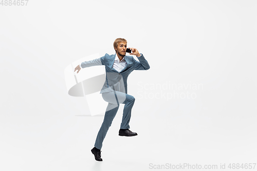 Image of Man in office clothes running, jogging on white background. Unusual look for businessman in motion, action. Sport, healthy lifestyle.