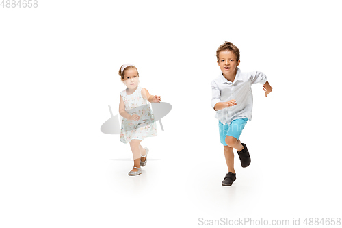 Image of Happy children, little caucasian boy and girl jumping and running isolated on white background