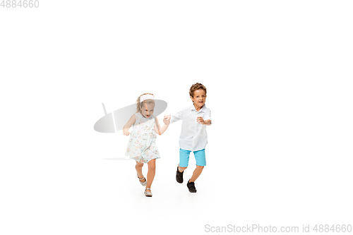 Image of Happy children, little caucasian boy and girl jumping and running isolated on white background