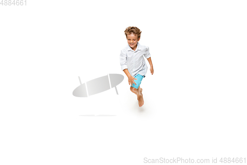 Image of Happy little caucasian boy jumping and running isolated on white background