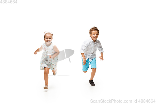 Image of Happy children, little caucasian boy and girl jumping and running isolated on white background