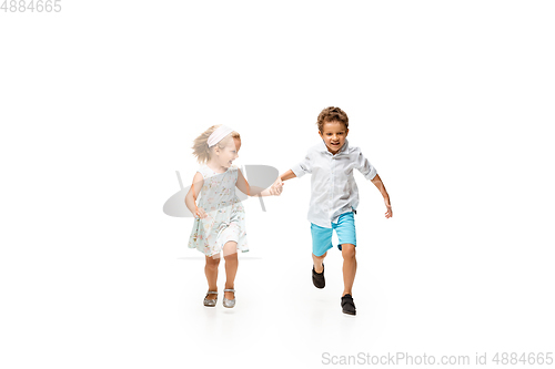 Image of Happy children, little caucasian boy and girl jumping and running isolated on white background