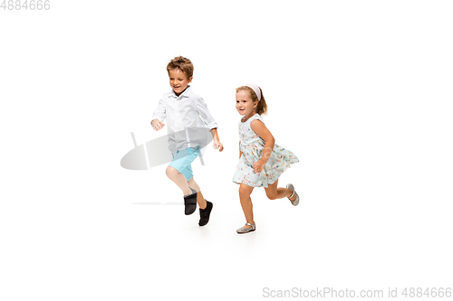 Image of Happy children, little caucasian boy and girl jumping and running isolated on white background