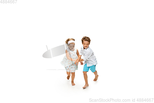 Image of Happy children, little caucasian boy and girl jumping and running isolated on white background