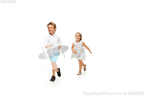 Image of Happy children, little caucasian boy and girl jumping and running isolated on white background