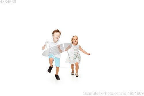 Image of Happy children, little caucasian boy and girl jumping and running isolated on white background