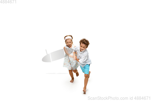 Image of Happy children, little caucasian boy and girl jumping and running isolated on white background