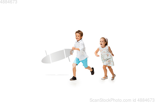 Image of Happy children, little caucasian boy and girl jumping and running isolated on white background