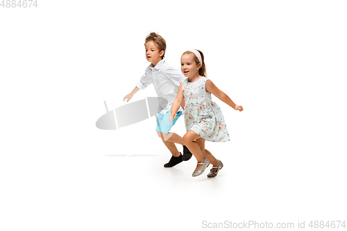 Image of Happy children, little caucasian boy and girl jumping and running isolated on white background
