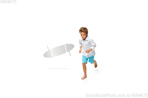 Image of Happy little caucasian boy jumping and running isolated on white background