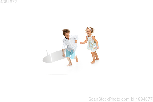 Image of Happy children, little caucasian boy and girl jumping and running isolated on white background