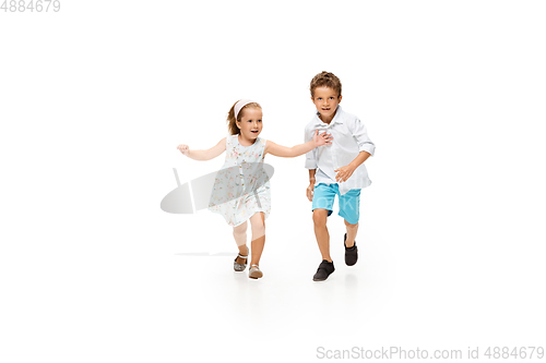 Image of Happy children, little caucasian boy and girl jumping and running isolated on white background