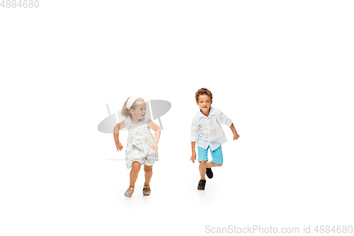 Image of Happy children, little caucasian boy and girl jumping and running isolated on white background