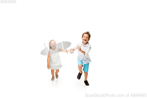 Image of Happy children, little caucasian boy and girl jumping and running isolated on white background