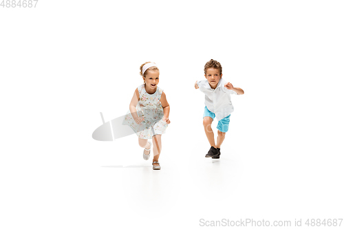 Image of Happy children, little caucasian boy and girl jumping and running isolated on white background